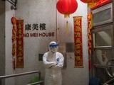 Một nhân viên y tế mặc đồ bảo hộ đứng bảo vệ bên ngoài lối vào tòa nhà chung cư ở Tsing Yi (Hồng Kông) sau khi phát hiện cư dân thứ hai nhiễm virus tại đây. Hơn 100 người sống tại tòa chung cư này đã được sơ tán (ảnh Getty Images)