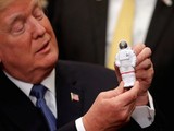 Tổng thống Mỹ Donald Trump cầm bức tượng đồ chơi một nhà du hành vũ trụ ở Nhà Trắng (Ảnh Reuters)