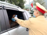 Công an TP Cẩm Phả vừa điều tiết giao thông vừa kết hợp với đo nhiệt độ người tham gia giao thông. Ảnh: UBND tỉnh Quảng Ninh.