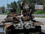 Một cặp đôi tò mò đứng trên chiếc xe tăng Nga bị phá hủy ở Kiev, Ukraine (Ảnh: DPA)