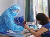 Nhân viên y tế hướng dẫn người dân khai báo y tế (Ảnh - BYT)