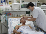 TS.BS. Nguyễn Tiến Dũng - Trung tâm Chống độc, Bệnh viện Bạch Mai khám bệnh cho một bệnh nhân ngộ độc methanol (Ảnh: Mai Thanh)