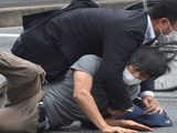 Lực lượng an ninh khống chế nghi phạm Tetsuya Yamagami (áo xám) tại hiện trường vụ nổ súng (Ảnh: AFP)