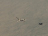 Máy bay ném bom Tu-160 của Nga được hộ tống bởi một chiếc Su-30SM (Ảnh: RT)