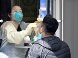 Một nhân viên y tế lấy mẫu xét nghiệm Covid-19 cho người dân ở Seoul (Ảnh: AFP).