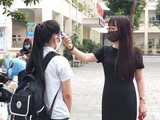 Cô giáo đo nhiệt độ cho học sinh (Ảnh- Minh Thuý)
