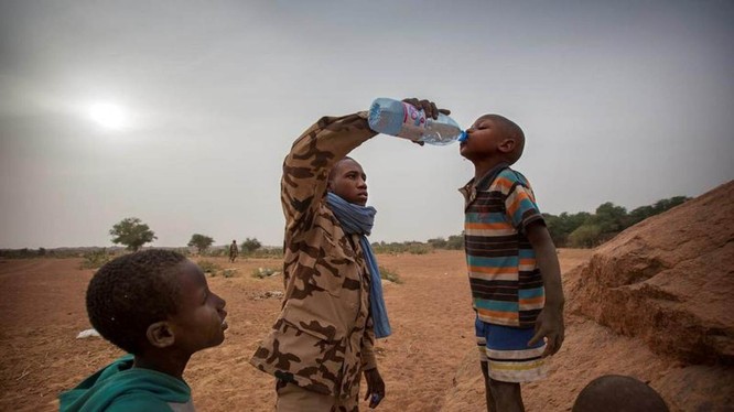 Một thành viên của đội MINUSMA Chadian cung cấp nước cho một cậu bé ở Kidal, Mali ngày 17.12.2016. Ảnh: Reuters