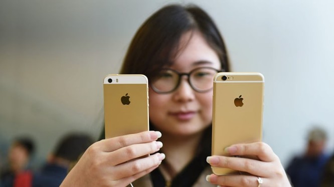 Một khách hàng đang so sánh iPhone SE và iPhone 6S tại một cửa hàng của Apple. Ảnh: CNBC
