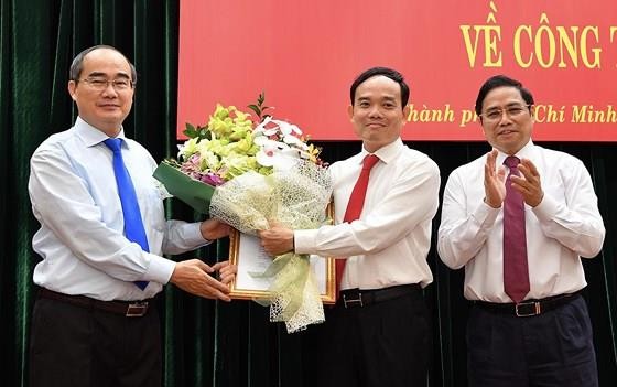 Bí thư Thành ủy TP.HCM Nguyễn Thiện Nhân (ngoài cùng, bên trái) tặng hoa chúc mừng tân Phó Bí thư Thường trực Thành ủy TPHCM Trần Lưu Quang (ở giữa) - Ảnh: SGGP