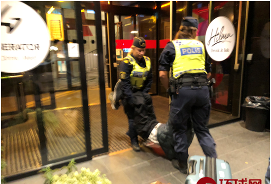 Bức ảnh được đăng trên báo chí Trung Quốc cho thấy cảnh sát Thụy Điển đang khiêng du khách ra khỏi khách sạn đưa lên xe