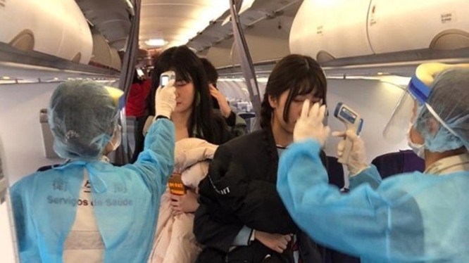 Đề phòng dịch bệnh lây lan, các nhân viên y tế sân bay Ma Cao lên máy bay đo thân nhiệt mọi hành khách trên chuyến bay từ Vũ Hán đến. (Ảnh: Đông Phương).