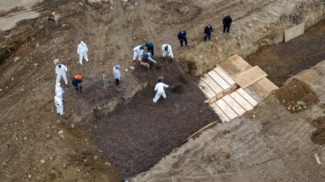 Hình ảnh các tù nhân được trưng dụng để chôn xác những nạn nhân của dịch bệnh COVID-19 trong các nấm mồ tập thể trên đảo Hart (Ảnh: Reuters).