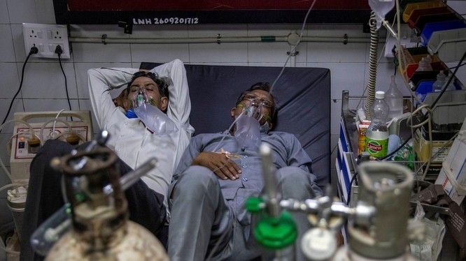 Số bệnh nhân liên tục gia tăng đã khiến nguồn lực y tế cạn kiệt. Trong ảnh: 2 bệnh nhân COVID-19 nằm chung một giường trong một bệnh viện ở Delhi (Ảnh: Reuters).