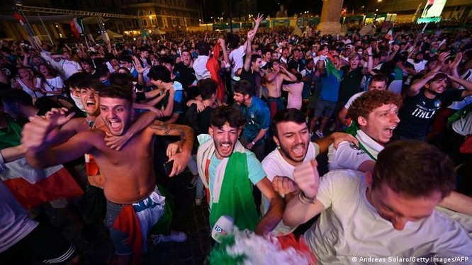 Tại một điểm xem công cộng ở Rome, người dân cổ vũ cho đội tuyển Italy, tình hình lây nhiễm COVID-19 trong trận đấu Italy-Tây Ban Nha vẫn chưa được biết (Ảnh: Deutsche Welle)