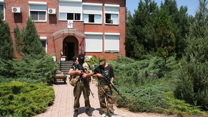 Binh sĩ tiểu đoàn Azov đứng trước ngôi nhà có gắn biểu tượng của Đức Quốc xã (Ảnh: Getty).