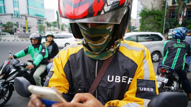 Jakarta, Indonesia: Một lái xe ôm Uber đang kiểm tra smartphone của mình, trong khi lái xe Go-Jek thì chở khách, phía bên phải là một xe ôm Grab. Ảnh: Straitstimes.com