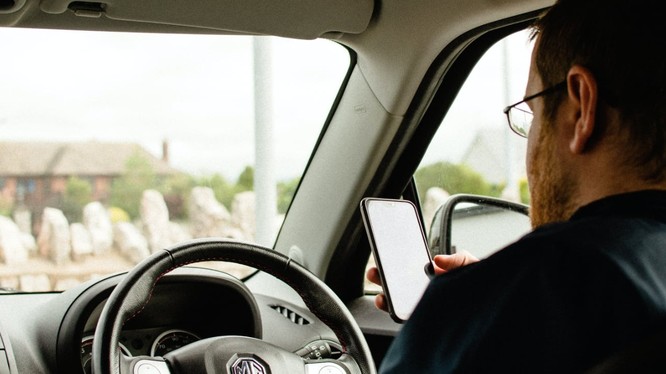 Nhiều tài xế ở Anh vẫn cố tình lách luật để sử dụng điện thoại trong khi lái xe. (Ảnh: Apple Insider)