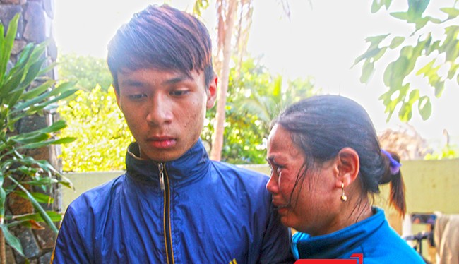 Bà Nguyễn Thị Năng (vợ ông Võ Văn Lựu, thuyền trưởng tàu QNg 90479TS) như không còn sức lực để khóc. Vùi đầu vào cậu con trai mới 16 tuổi Võ Văn Cầu trở về sau cơn hoạn nạn.