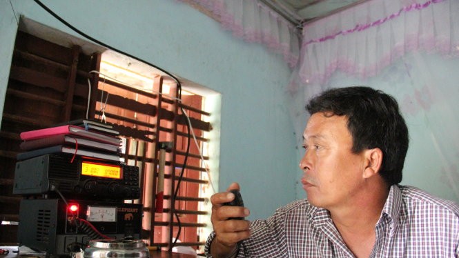 Ông Nguyễn Thanh Nam, người trực icom cộng động xã Bình Châu vẫn đang tiếp tục liên lạc với tàu cá QNg 95861 để theo dõi thông tin tàu đang về đất liền - Ảnh: Trần Mai