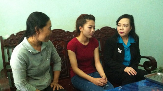 Bộ trưởng Nguyễn Thị Kim Tiến (bìa phải) thăm hỏi đại diện gia đình em Vi - Ảnh: Hà Bình