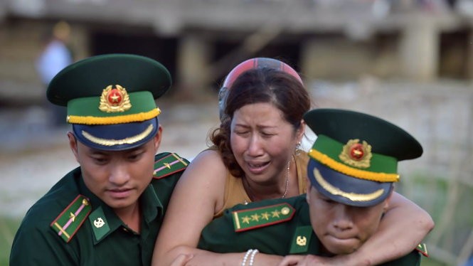Vợ của nạn nhân Phạm Tấn Cường khóc ngất trong khi được lực lượng biên phòng Đà Nẵng dìu đi - Ảnh: LÊ HẢI SƠN