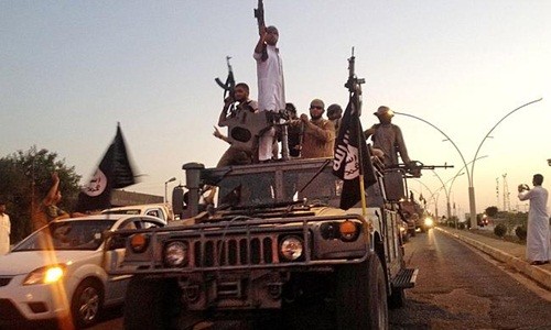 Phiến quân Nhà nước Hồi giáo diễu hành trên một chiếc xe chiếm được của lực lượng an ninh Iraq. Ảnh: AP