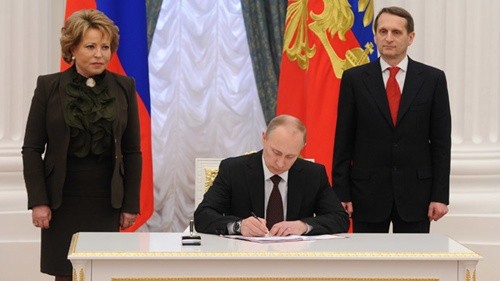 Tổng thống Nga Vladimir Putin ký ban hành luật về sáp nhập Crimea vào tháng 3 năm ngoái. Ảnh: RIANovosti