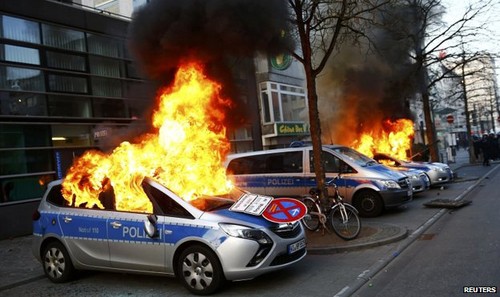 Những người biểu tình phóng hỏa nhiều xe cảnh sát. Ảnh: Reuters.