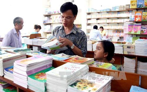 Phụ huynh học sinh chọn mua sách giáo khoa tại siêu thị của công ty ở số 45b Lý Thường Kiệt, quận Hoàn Kiếm, Hà Nội. Ảnh: Quý Trung - TTXVN