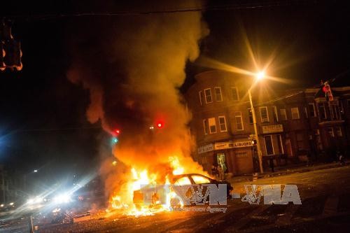 Xe bị người biểu tình phóng hỏa. Ảnh: AFP/TTXVN