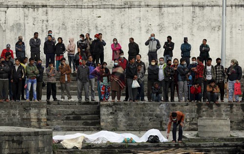 Một thanh niên thực hiện nghi thức tang lễ cho một người thân thiệt mạng vì động đất bên bờ sông ở Kathmandu. Ảnh: Reuters