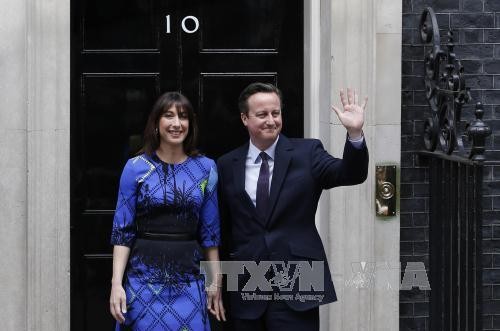 Thủ tướng Anh David Cameron (phải) và phu nhân Samantha bên ngoài Tòa nhà Số 10 phố Downing ở London ngày 8/5. Ảnh: AFP/ TTXVN