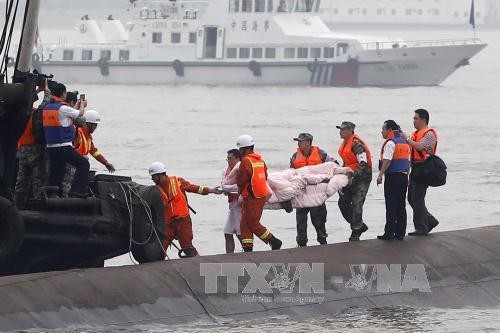 Chuyển thi thể hành khách trong vụ chìm tàu ngày 2/6. Ảnh: AFP/ TTXVN 