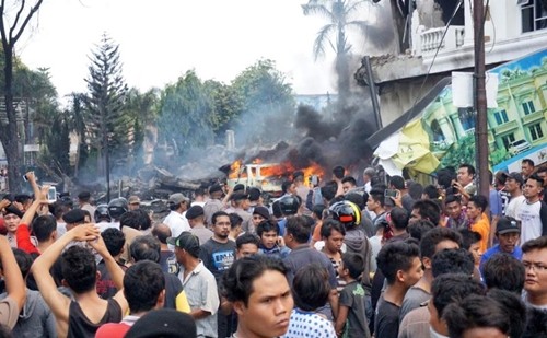 Người dân tập trung gần hiện trường máy bay rơi ở thành phố Medan, đảo Sumatra. Ảnh: AFP.