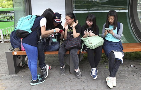 Thiếu niên Hàn Quốc sử dụng smartphone tại nhà chờ xe buýt ở Seoul.