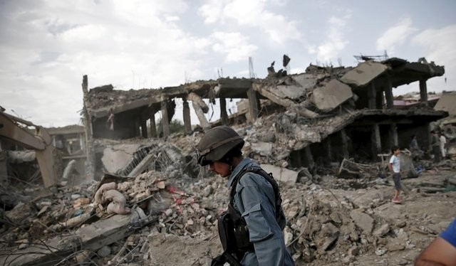 Một cảnh sát Afghanistan tại hiện trường vụ đánh bom xe - Ảnh: Reuters