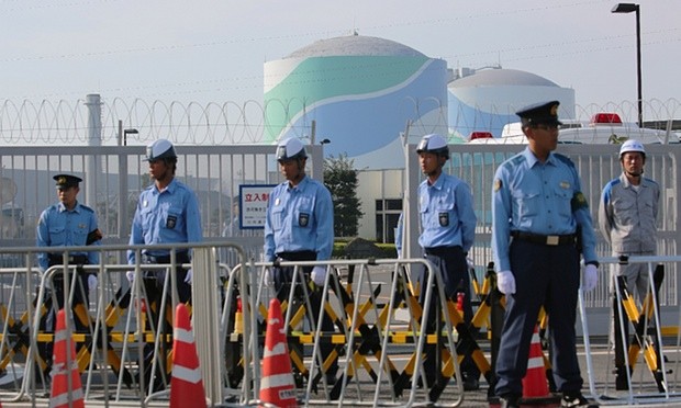 Cảnh sát đứng canh gác ngoài khu Tổ hợp hạt nhân Sendai, ngăn chặn người biểu tình phản đối tái khởi động chương trình.