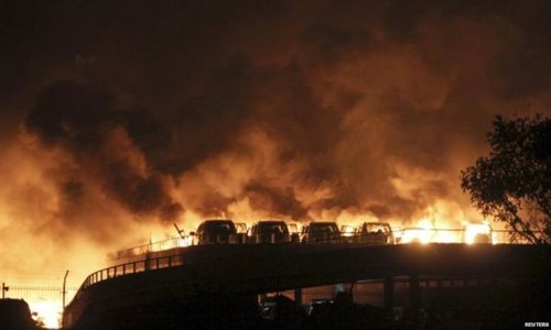 Sức ép từ vụ nổ khiến các tòa nhà rung chuyển và nhấn chìm nhiều bãi đỗ xe trong biển lửa. Ảnh: Reuters.