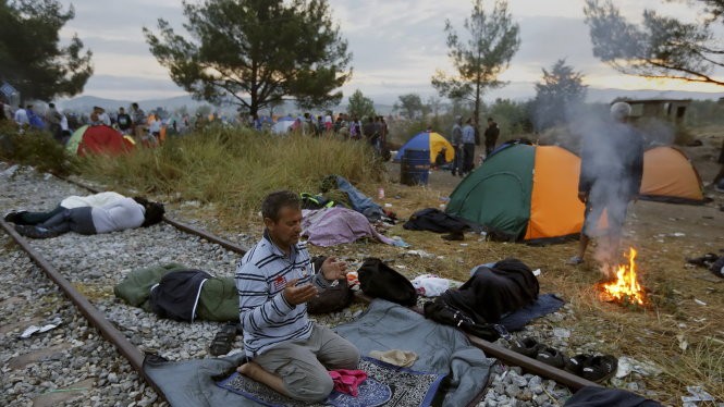 Người nhập cư Syria nghỉ chân ở biên giới Hi Lạp - Macedonia - Ảnh: Reuters