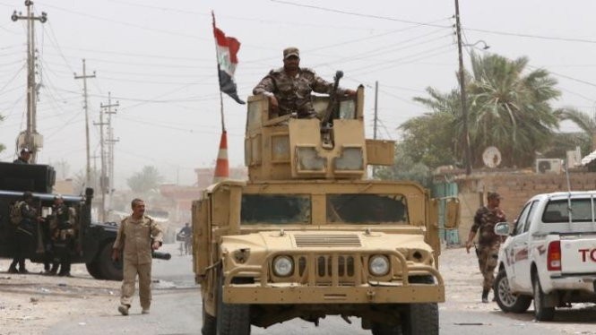Một binh sỹ thuộc lực lượng an ninh Iraq ở trên chiếc xe quân sự tại thành phố Baiji - Ảnh: Reuters