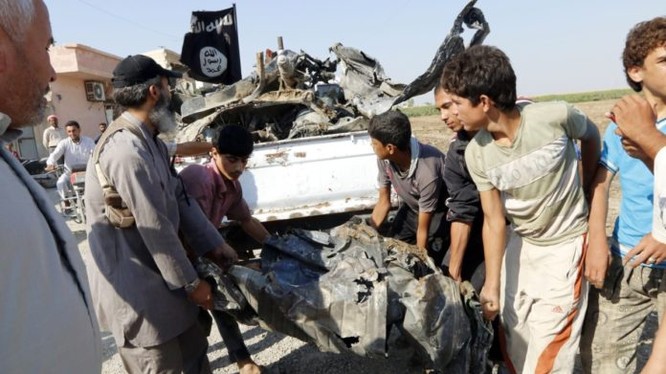 Các tay súng IS thu lượm mảnh xác máy bay quân đội Syria
