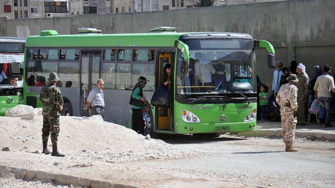 Xe buýt chở các tay súng Hồi giáo cực đoan di tản về Idlib - ảnh Masdar News