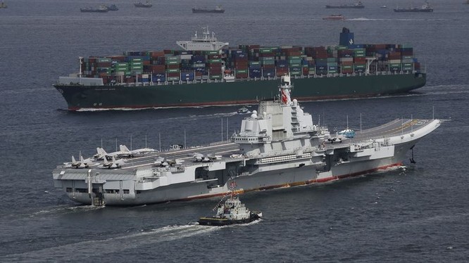 Tàu sân bay Liêu ninh trên nền một chiếc tàu vận tải lớn của Trung Quốc