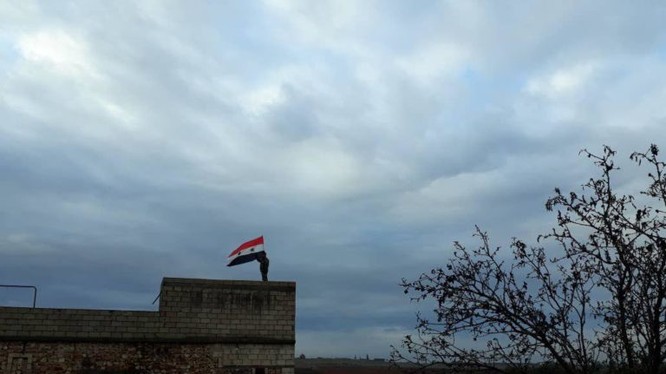 Quân đội Syria thượng cờ trên nóc nhà cao tầng của thành phố Manbij, Aleppo.