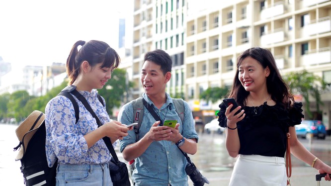 Các bạn trẻ sử dụng wifi miễn phí trên phố đi bộ Nguyễn Huệ. Nguồn Thanh Niên 