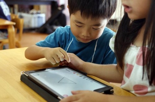 Học sinh trường mẫu giáo Coby (Yoshikawa, Saitama, Nhật Bản) đang học vẽ trên một thiết bị công nghệ. Ảnh: AP. 