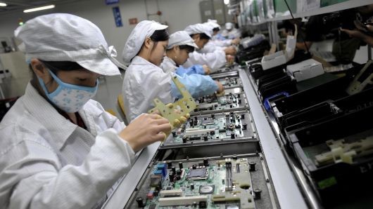 Công nhân đang lắp ráp các linh kiện điện tử tại nhà máy của Foxconn ở Trung Quốc. Ảnh: AFP.