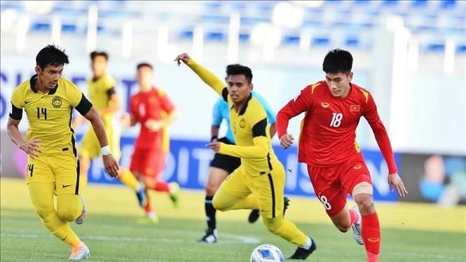 Tiền đạo Nhâm Mạnh Dũng đi bóng qua cầu thủ Malaysia