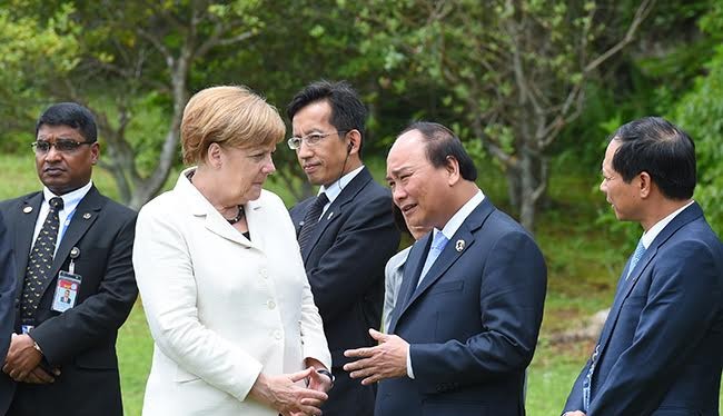 Thủ tướng Việt Nam và Thủ tướng Đức trao đổi bên lề hội nghị.