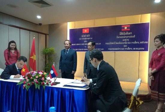 Lễ ký kết thỏa thuận ghi nhớ hợp tác giữa NEAC và LANIC có sự chứng kiến của Bộ trưởng Bộ TT&TT Trương Minh Tuấn và Bộ trưởng Bộ Bưu chính Viễn thông Lào Thansamay Kommasith (Ảnh do NEAC cung cấp)